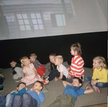 dzieci oglądają widowisko w planetarium objazdowym