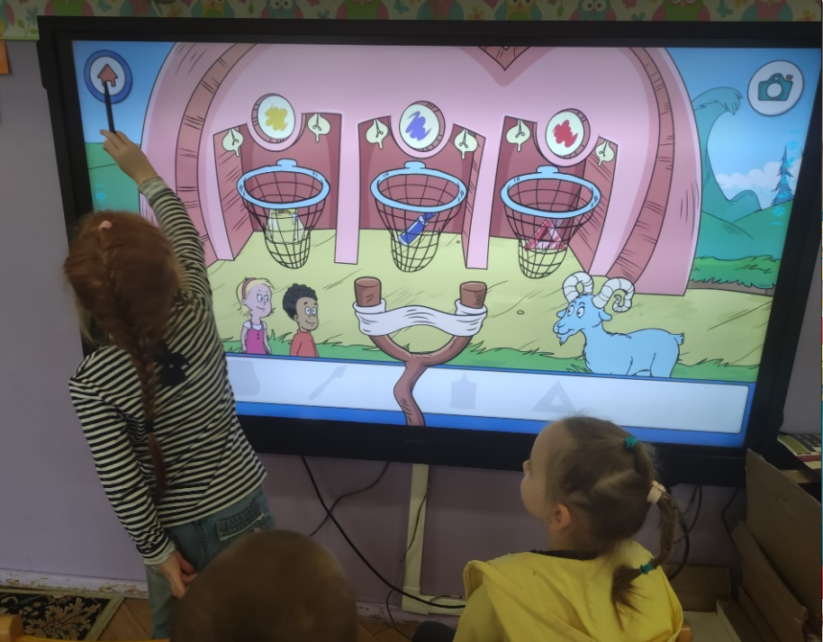 dzieci grają w grę edukacyjną na ekranie multimedialnym