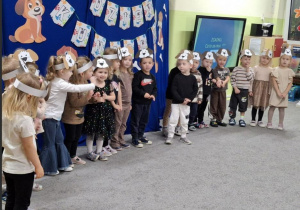 Dzieci z grupy 2 w maskach pieska mówią wiersz o kundelku.