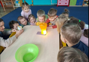 dzieci obserwują eksperyment z kolorowym światłem