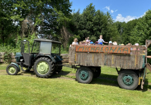 dzieci jadą wozem podczepionym do traktora