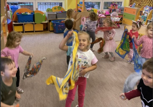 Dzieci tańczą z kolorowymi chustkami