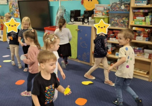 Dzieci biegają po dywanie po kolorowych kropkach